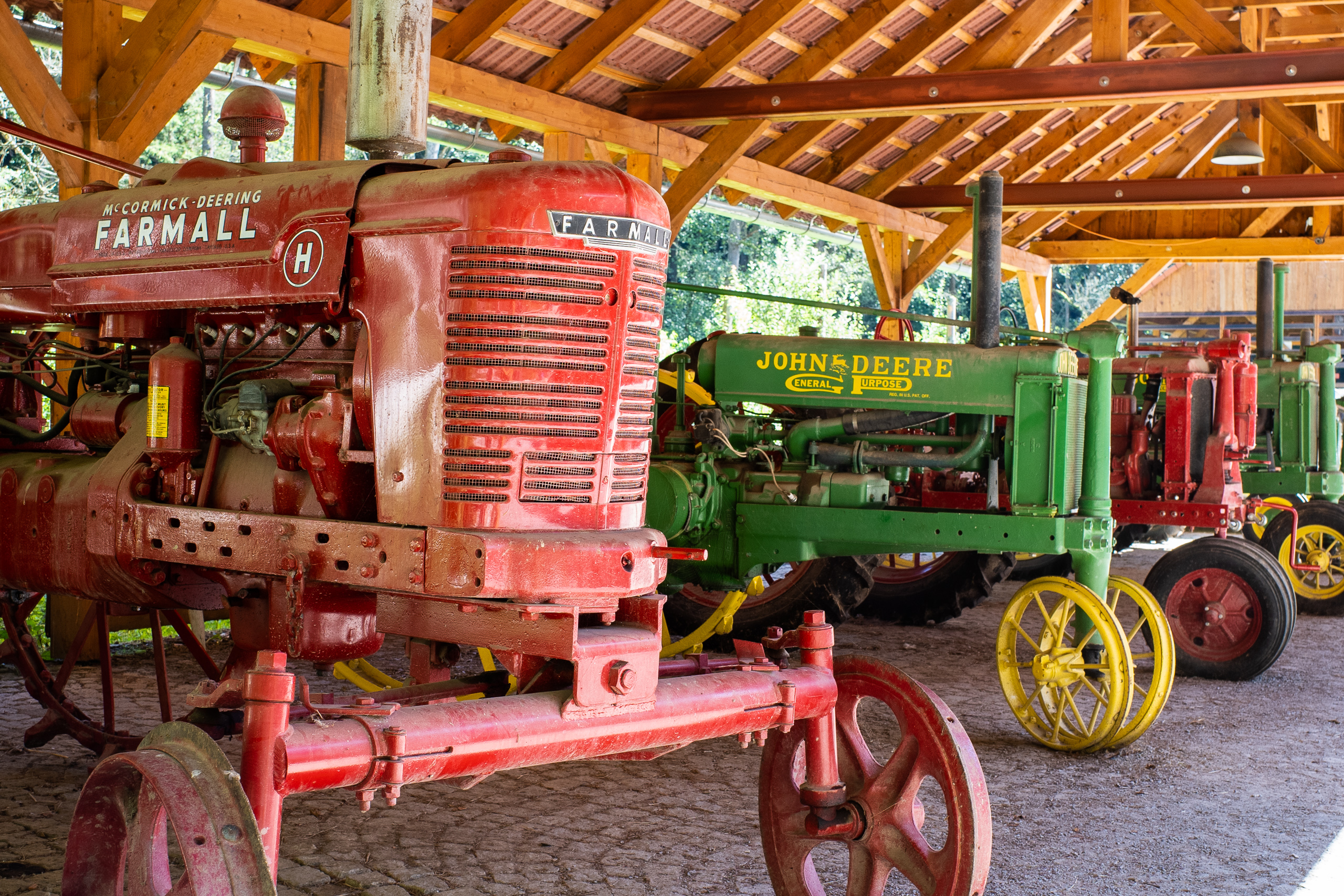 Farmall und John Deere unter dem Holzdach – die Traktoren vor der alten Mühle